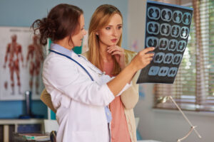 Doctora explicando pruebas médicas a una paciente con dolor persistente